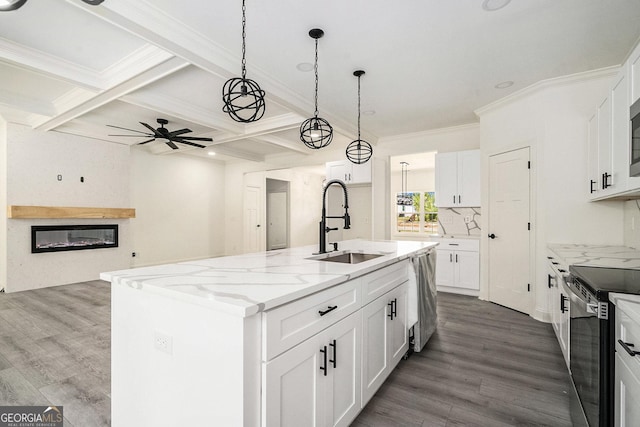 kitchen featuring a center island with sink, white cabinets, sink, ceiling fan, and stainless steel appliances