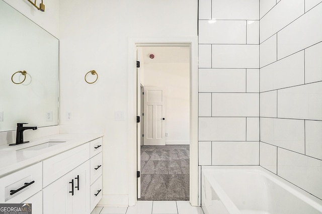 bathroom featuring tile patterned flooring, a washtub, and vanity