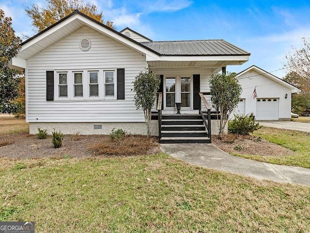 bungalow featuring covered porch, a front yard, and a garage