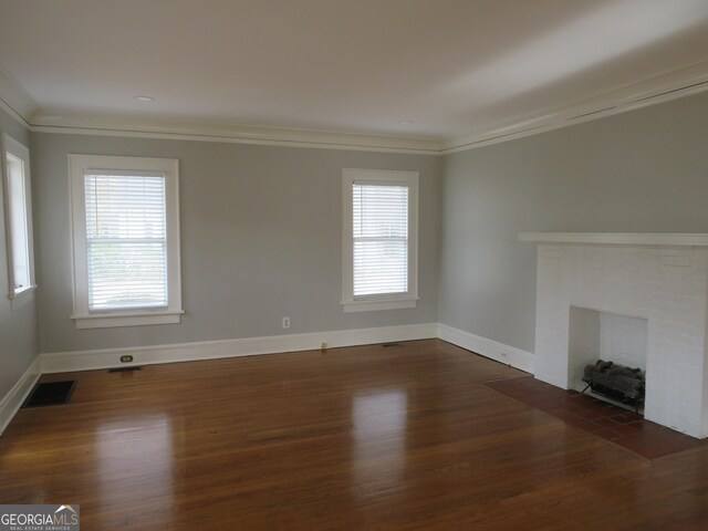 unfurnished living room featuring dark hardwood / wood-style flooring, crown molding, and a healthy amount of sunlight