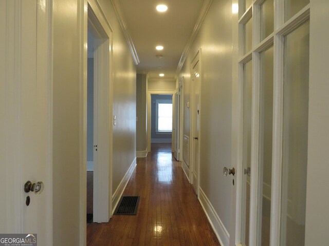 hallway with ornamental molding and dark wood-type flooring