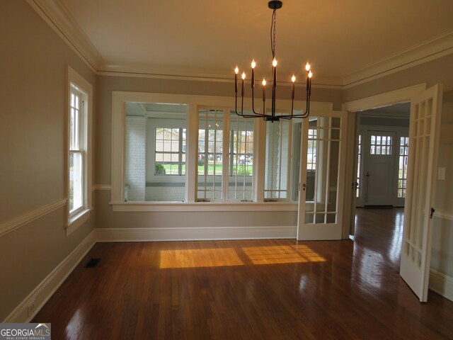 unfurnished dining area featuring an inviting chandelier, a wealth of natural light, and ornamental molding