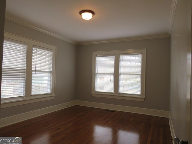 spare room with dark hardwood / wood-style flooring, plenty of natural light, and crown molding