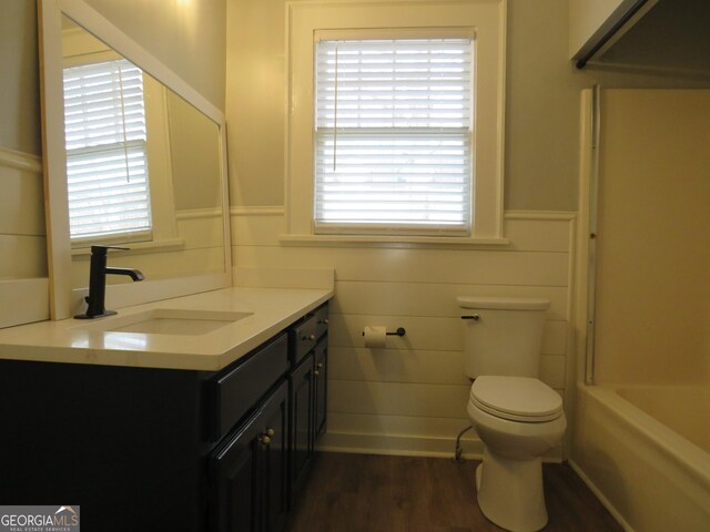 full bathroom featuring vanity, toilet, wood-type flooring, and a wealth of natural light