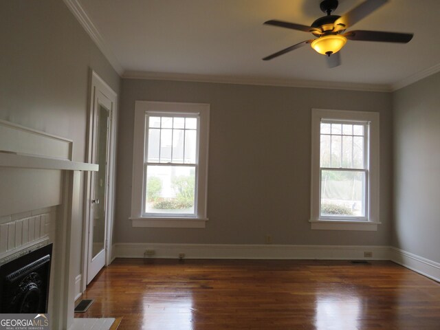 unfurnished living room with ceiling fan, ornamental molding, and dark wood-type flooring