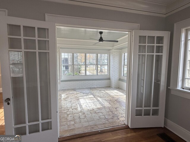 unfurnished sunroom featuring ceiling fan and a healthy amount of sunlight