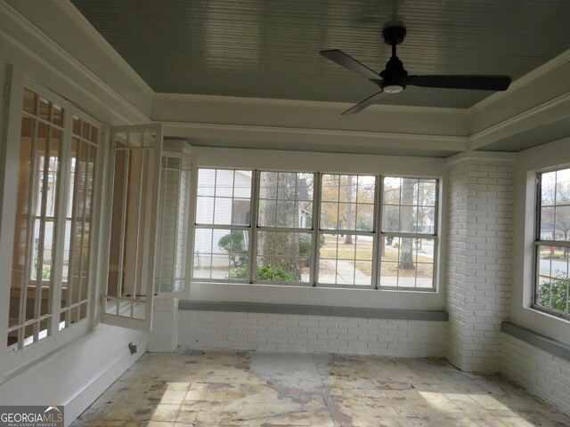 unfurnished sunroom with ceiling fan