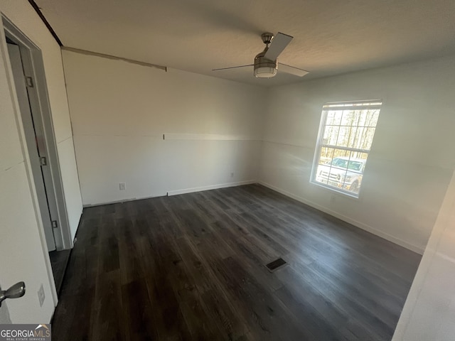 unfurnished room with ceiling fan and dark hardwood / wood-style flooring