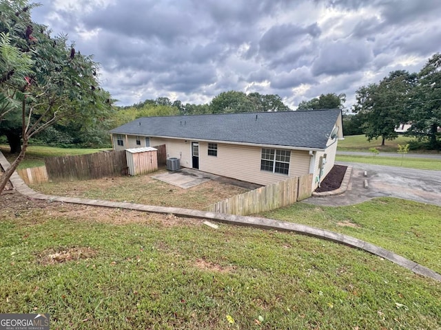 back of property featuring a yard and central AC unit