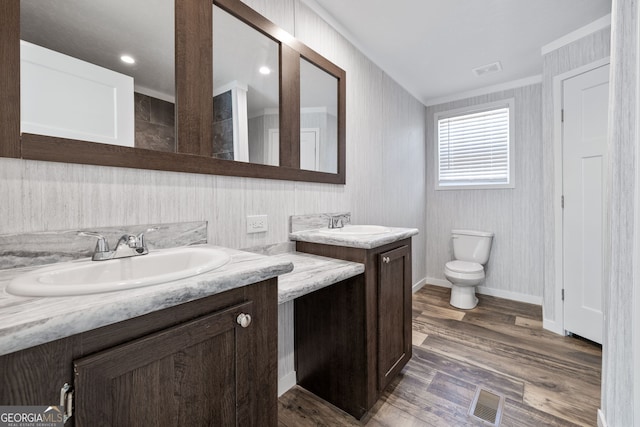 bathroom with vanity, hardwood / wood-style flooring, toilet, and crown molding