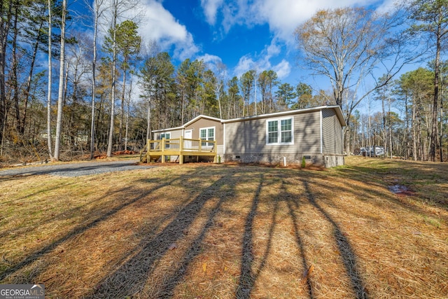 view of front facade featuring a wooden deck and a front yard