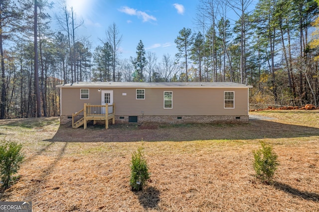 rear view of property featuring a lawn