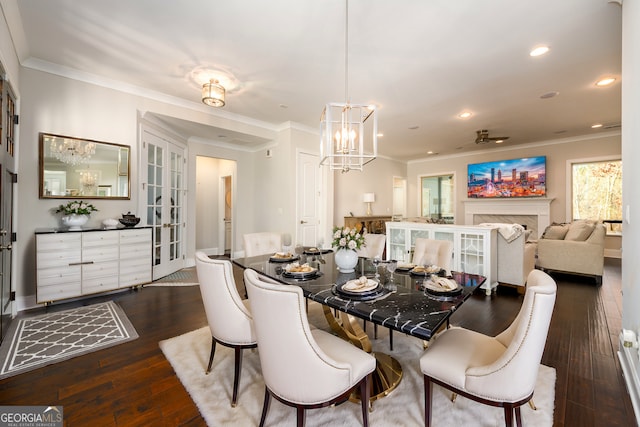 1560 Tapestry Rdg, Lawrenceville, GA 30045 - dining space featuring a chandelier, crown molding, dark wood-style floors, recessed lighting, and a fireplace