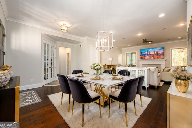 1560 Tapestry Rdg, Lawrenceville, GA 30045 - dining area with a chandelier, dark wood-type flooring, crown molding, recessed lighting, and a fireplace