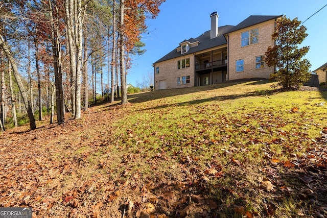 1560 Tapestry Rdg, Lawrenceville, GA 30045 - back of house featuring a lawn, a chimney, a balcony, and brick siding
