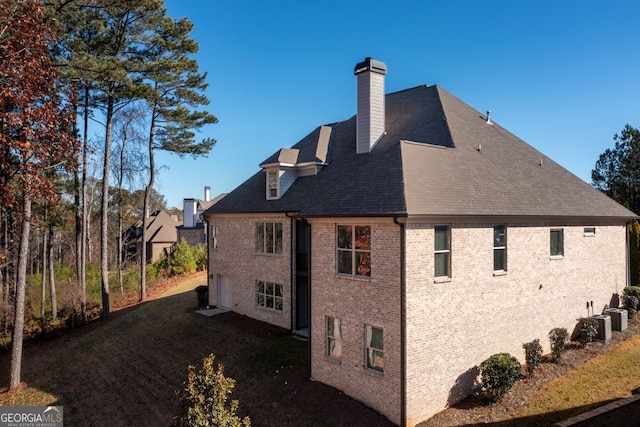 1560 Tapestry Rdg, Lawrenceville, GA 30045 - view of side of property with brick siding, a chimney, roof with shingles, and a lawn