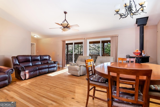 284 Tickanetley Rd, Ellijay, GA 30536 - dining area featuring a wood stove, light wood-style floors, a ceiling fan, and a chandelier