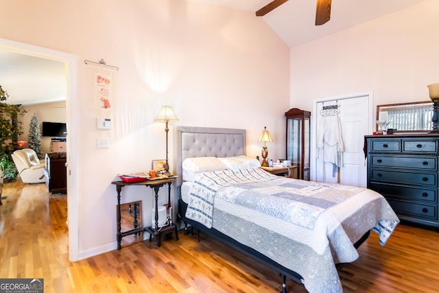 bedroom featuring baseboards, high vaulted ceiling, and wood finished floors