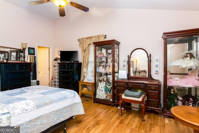 bedroom with ceiling fan, lofted ceiling, wood finished floors, and radiator heating unit