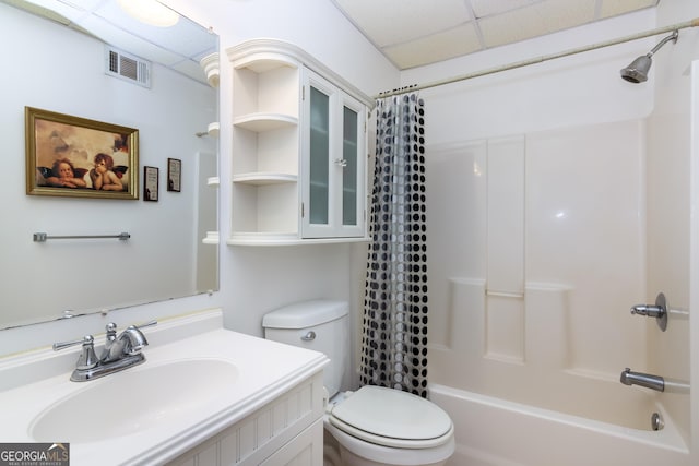 bathroom featuring vanity, visible vents, a paneled ceiling, shower / bath combo with shower curtain, and toilet