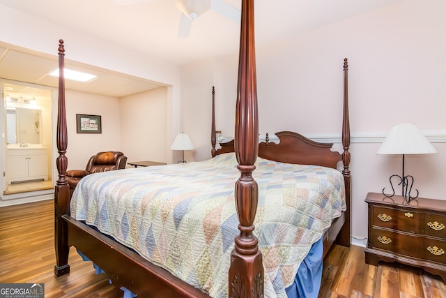 bedroom featuring ceiling fan, wood finished floors, and a sink