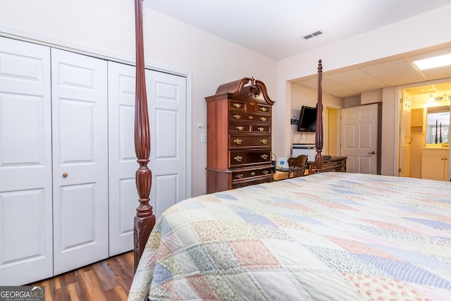 bedroom featuring visible vents, a closet, and wood finished floors