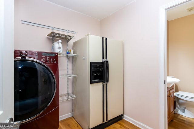 washroom featuring visible vents, baseboards, light wood-type flooring, laundry area, and washer / clothes dryer