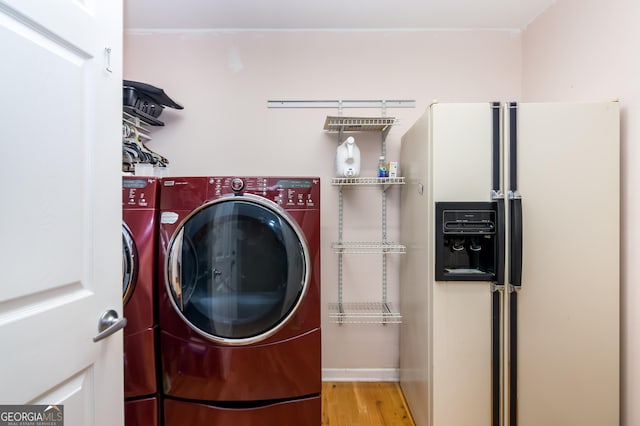 laundry room with wood finished floors, washing machine and dryer, and laundry area