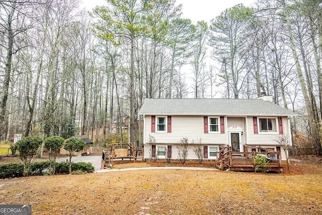 split foyer home featuring a front lawn and a deck