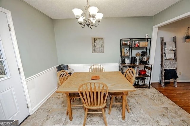 dining room featuring hardwood / wood-style flooring, a notable chandelier, and a textured ceiling