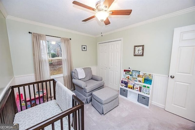 bedroom with ceiling fan, ornamental molding, light colored carpet, and a closet