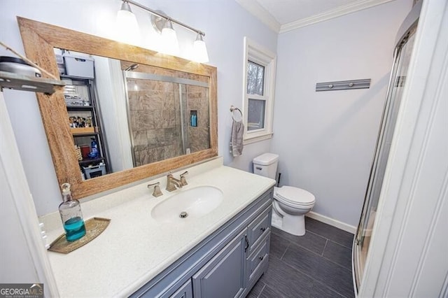 bathroom with ornamental molding, toilet, a shower with door, and vanity