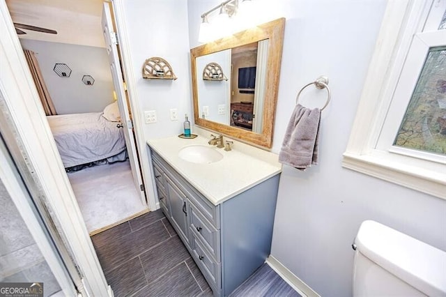 bathroom with vanity, toilet, and ceiling fan