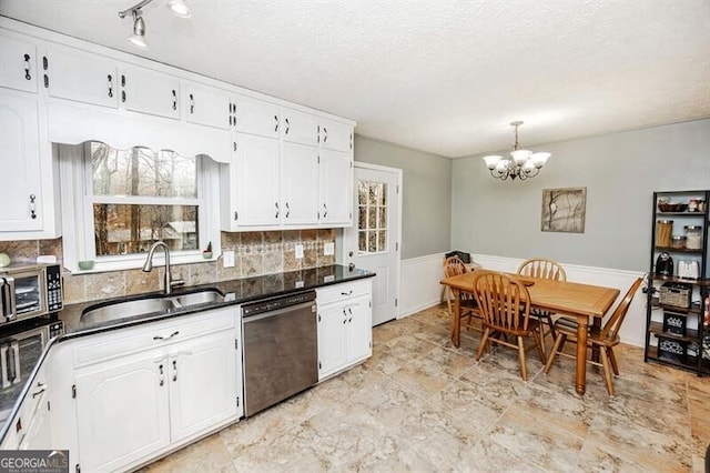 kitchen with white cabinetry, dishwasher, sink, and a notable chandelier