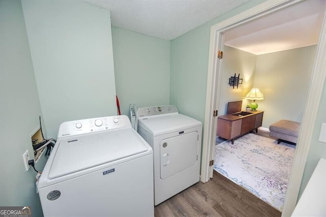 laundry room featuring washing machine and dryer and light wood-type flooring