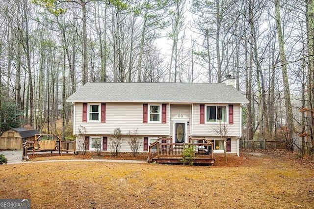 bi-level home with a deck and a storage shed