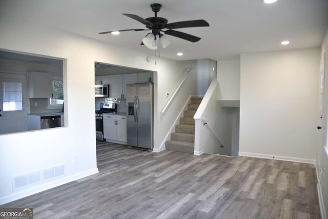 unfurnished living room featuring ceiling fan and wood-type flooring