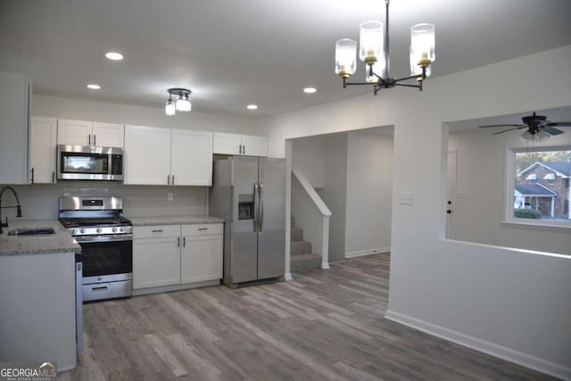 kitchen featuring white cabinets, wood-type flooring, stainless steel appliances, and sink