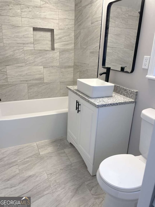 full bathroom with vanity, tiled shower / bath combo, and toilet