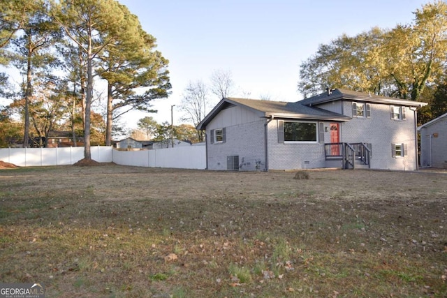 back of house featuring a lawn and central AC