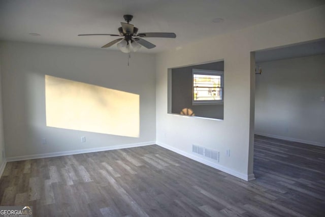 empty room featuring ceiling fan and dark wood-type flooring