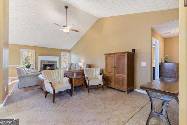 carpeted living room featuring lofted ceiling, ceiling fan, a fireplace, and a textured ceiling