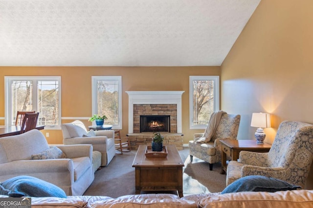 living room with lofted ceiling, a fireplace, a textured ceiling, and dark colored carpet