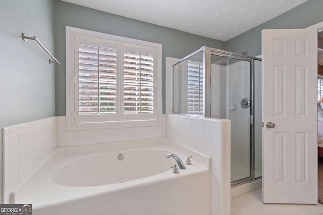 bathroom with independent shower and bath and a textured ceiling