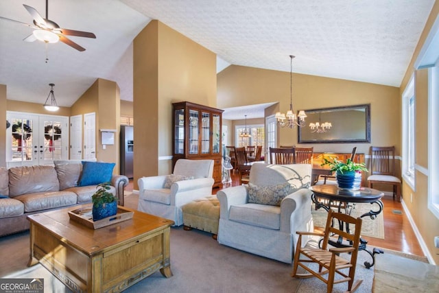 living room with hardwood / wood-style flooring, a textured ceiling, ceiling fan with notable chandelier, vaulted ceiling, and french doors