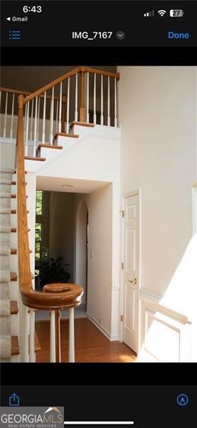 staircase with wood-type flooring and a high ceiling