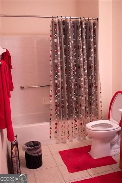 bathroom with tile patterned floors, toilet, and shower / bath combo with shower curtain