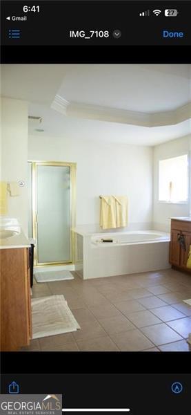 bathroom with tile patterned floors, vanity, and plus walk in shower