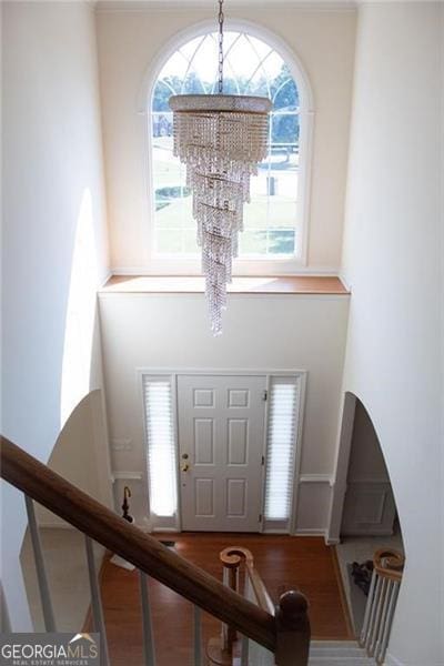 foyer featuring wood-type flooring, an inviting chandelier, and a healthy amount of sunlight