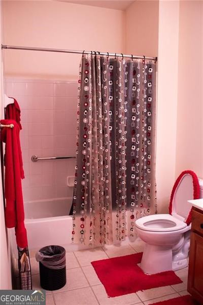 full bathroom with tile patterned flooring, shower / bath combo, vanity, and toilet